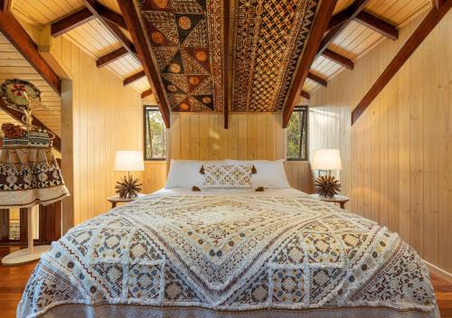 a bedroom with a bed in a room with wooden walls at The Forest Buré - Fijian Hinterland Retreat in Ninderry