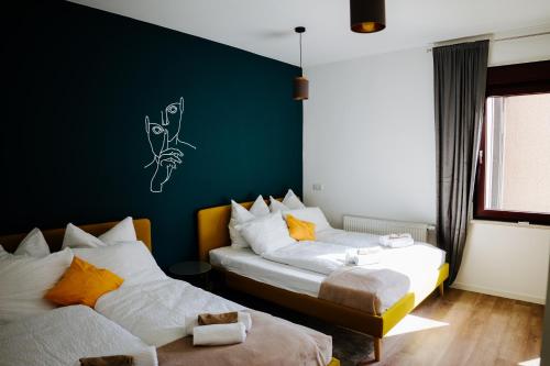 Jenapartments Design Loft, Damenviertel im Stadtzentrum في جينا: سريرين في غرفة ذات جدار أخضر