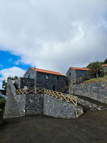 a castle with a stone wall and a bridge at Quinta do Caminho da Igreja TER-Casas de Campo in Velas