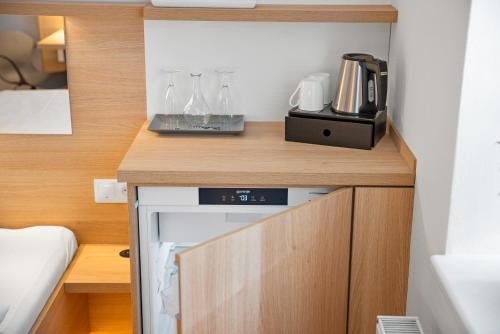 a small kitchen with a counter with glasses on it at Penzion Sirius in Vyškov