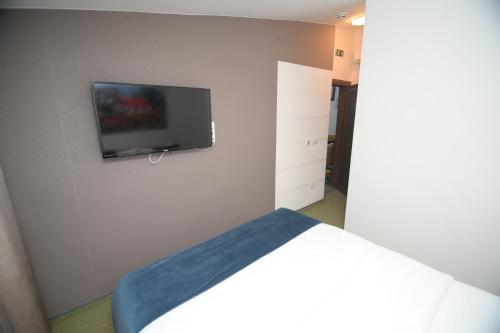 a bedroom with a flat screen tv on the wall at Apartmani Čarolija in Lučani