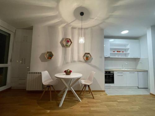 uma cozinha com uma mesa e duas cadeiras e uma mesa em Vera's place em Novi Sad