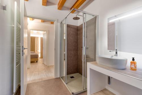 een badkamer met een wastafel en een glazen douche bij Concilium in Trento