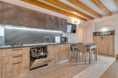 a kitchen with wooden cabinets and a table with chairs at Concilium in Trento