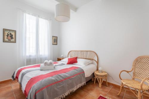 a bedroom with a bed with a red and white blanket at La Piazzetta - Terrasse au calme in Marseille