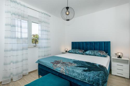 a bedroom with a blue bed and a window at Apartment ANIKA* brand new and close to beach in Punat