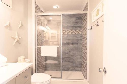 La salle de bains est pourvue de toilettes et d'une douche en verre. dans l'établissement Port O' Call B201 - Direct Oceanfront Views, à Isle of Palms