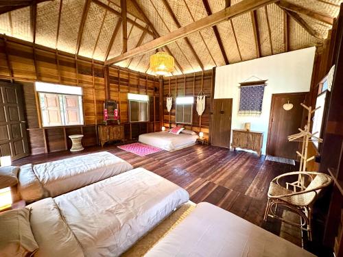een slaapkamer met 2 bedden in een kamer met houten vloeren bij La Maison - Chiangmai in Mae Taeng