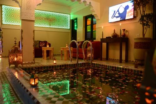 een zwembad in een woonkamer met kaarsen in het water bij Riad Bab Nour in Marrakesh