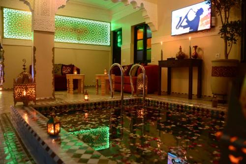 a pool in a living room with candles in the water at Riad Bab Nour in Marrakesh