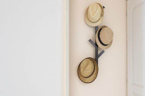 two hats hanging on a wall next to a door at Alpha & Omega in Karpathos Town