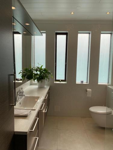 bagno con lavandino, servizi igienici e specchio di Family villa a Keflavík