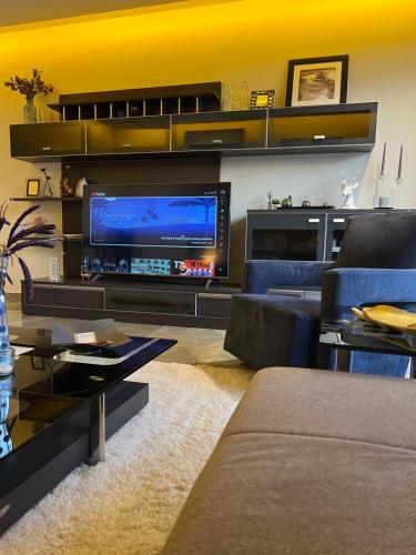 ein Wohnzimmer mit einem großen TV und einem Sofa in der Unterkunft شقة فاخرة في حطين in Riad