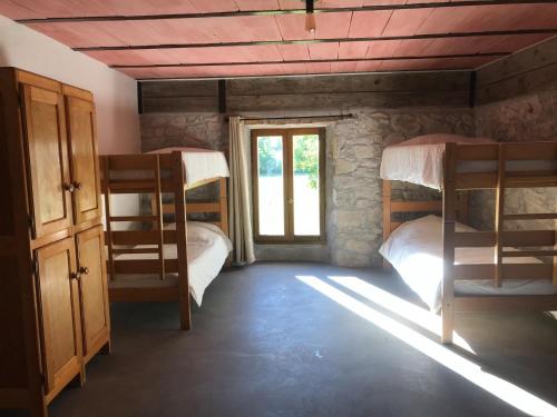 Pokój z 2 łóżkami piętrowymi i oknem w obiekcie Gîte d'étape Bastide Petra Castellana Verdon w mieście Castellane