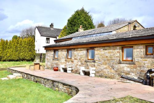 a stone house with a patio in front of it at The Coach House in Baxenden