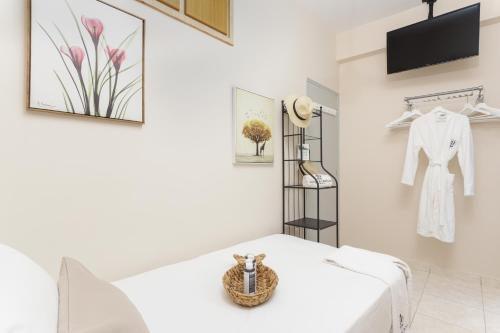 a room with a white bed and a shelf at Alpha & Omega in Karpathos Town