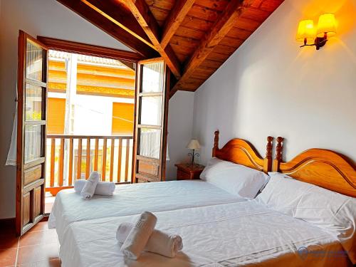 una camera da letto con un grande letto con lenzuola bianche di Las Encinas adosado en Pechon a Pechón