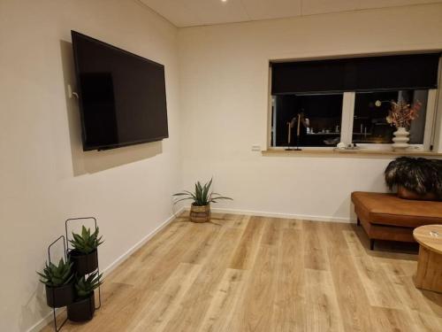 Il comprend un salon doté d'un canapé et d'une télévision à écran plat. dans l'établissement New flat with hot tub - No1, à Oyndarfjørður