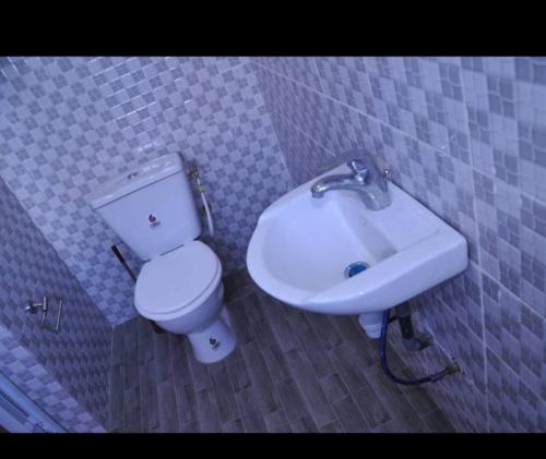a bathroom with a toilet and a sink at RÉSIDENCE K&K - Lomé-Kégué-Kpatcha in Kopégan