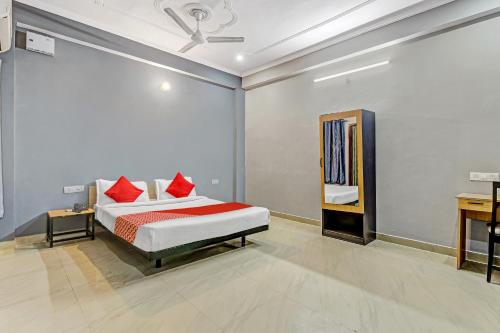 1 dormitorio con 1 cama con almohadas rojas en Orphic Inn Near Munshi Pulia Metro Station, en Chinhat