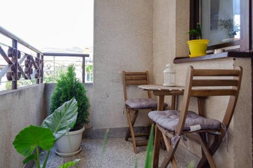uma varanda com 2 cadeiras e uma mesa na varanda em Cozy flower apartment em Vranje