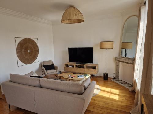 a living room with a couch and a tv at Appartement Enghien-les-Bains in Enghien-les-Bains