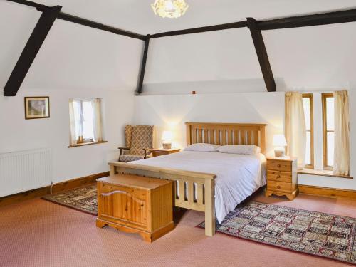 Loders的住宿－The Retreat，一间卧室配有一张床、一把椅子和窗户。