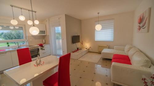 a living room with a white couch and red chairs at Sea & Sun 4* in Banjole