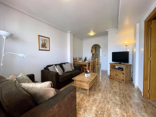- un salon avec un canapé et une télévision dans l'établissement La Ciñuelica R14 First Floor Apartment L126, à Orihuela