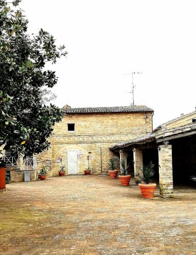 a large brick building with potted plants in front of it at camere in Villa Luzi in Treia