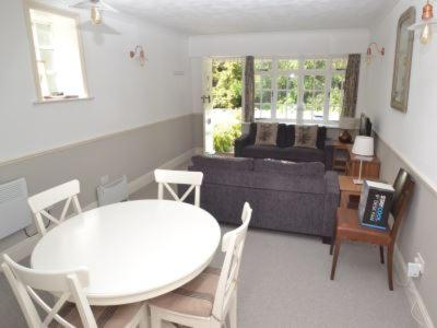 ein Wohnzimmer mit einem weißen Tisch und einem Sofa in der Unterkunft Quince Cottage in Ventnor