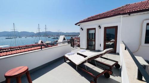 a balcony with two chairs and a boat on the water at Vista House Marmaris in Marmaris