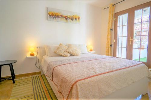 een slaapkamer met een bed met 2 lampen en een raam bij Beautiful 2 Bedroom Bungalow with Communal Pools in Villamartin