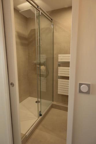 une douche avec une porte vitrée dans une salle de bain dans l'établissement Le pied dans l'eau, à Palavas-les-Flots