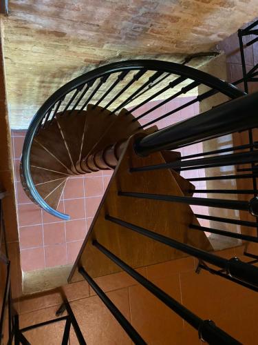 a spiral staircase in a room with pink tiles at camere in Villa Luzi in Treia