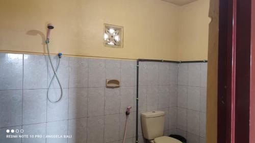 uma casa de banho com um chuveiro e um WC. em Tengger Indah Bromo by ABM em Bromo