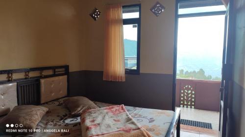 a small bedroom with a bed and a window at Tengger Indah Bromo by ABM in Bromo