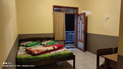 a bedroom with a bed and a window and a door at Tengger Indah Bromo by ABM in Bromo