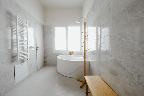 a white bathroom with a tub and a window at LB Luxury Apartments in Volos