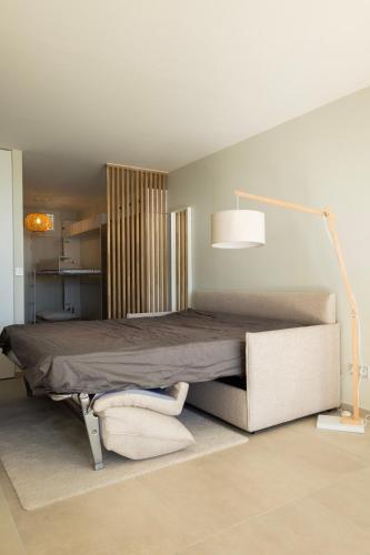 - une chambre avec un lit doté d'une lampe et d'une chaise dans l'établissement Le pied dans l'eau, à Palavas-les-Flots