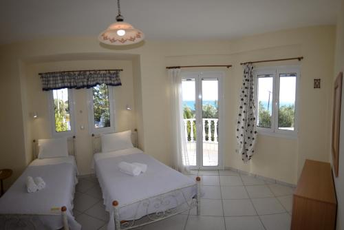 a bedroom with two beds and a balcony at Villa Alex in Rizá