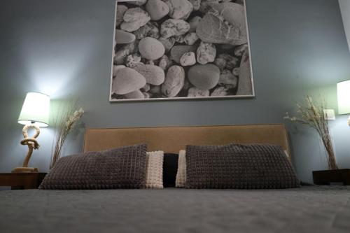 1 cama con 2 almohadas y una foto en la pared en Marina Zeas Seaside Studio-MarinaQ, en Pireo