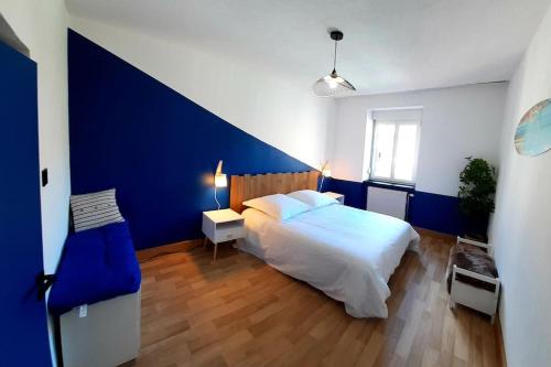 1 dormitorio con 1 cama grande y pared azul en La cachette - Maison centre en Mulhouse