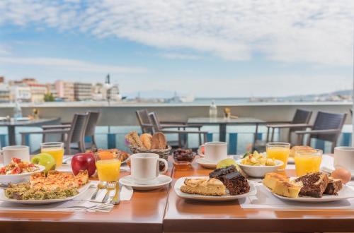a table with plates of food and drinks on it at Lesvion Hotel in Mytilene