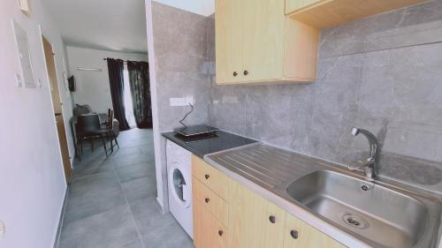 a kitchen with a sink and a washing machine at STAY Nissi Gusto 2 in Ayia Napa
