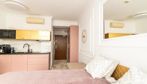 um quarto com uma cama e uma cozinha com um lavatório em ARKA APARTAMENT DELUXE 723b em Kolobrzeg