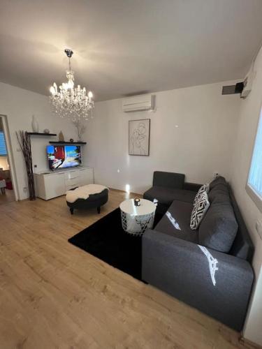 a living room with a couch and a tv at Apartments Stone in Vrsi