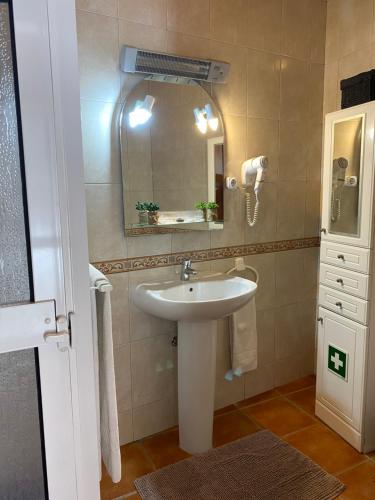 a bathroom with a sink and a mirror at Casa dos Montes in Alvor