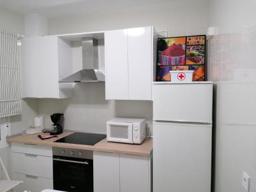 een witte keuken met een koelkast en een magnetron bij Alojamiento Dunas centro in Tabernas