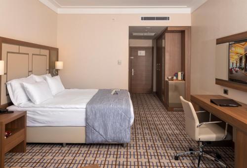 a hotel room with a bed and a desk at Ramada Plaza by Wyndham Rize in Rize